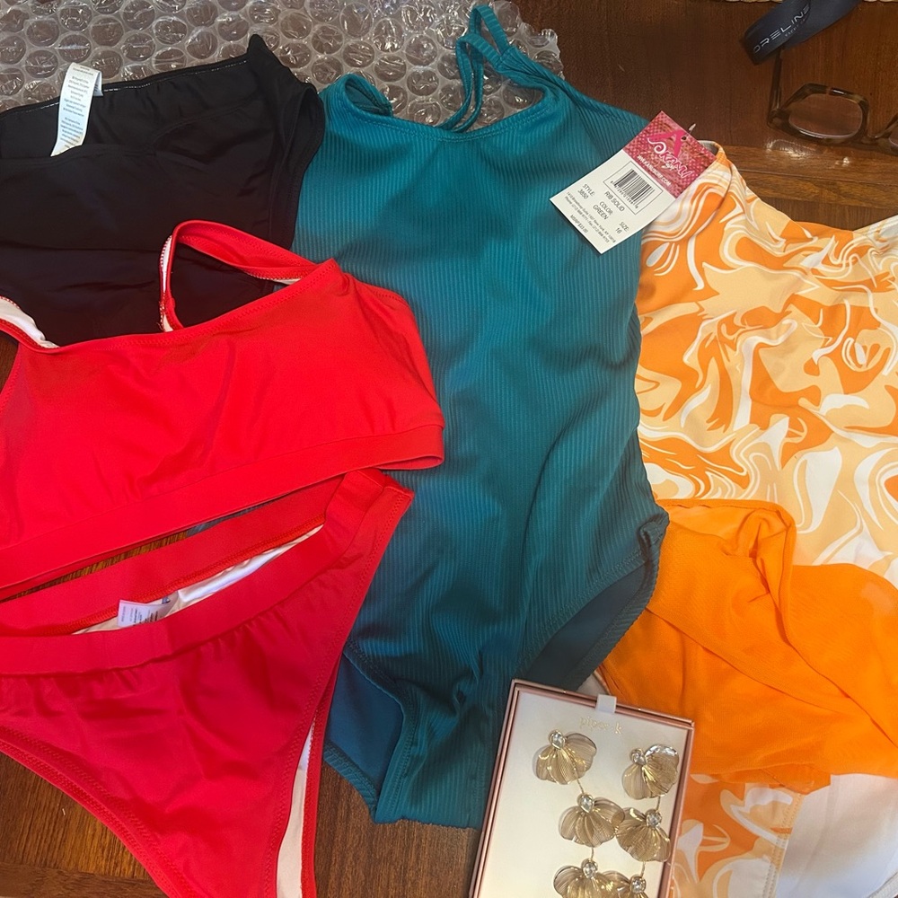 Three NEW WITH TAGS bathing suits plus a black bikini bottom and a special gift!